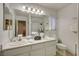 Well-lit bathroom featuring a double sink vanity, large mirror, and a shower with glass doors at 1721 Sweet Pea Ave, Las Vegas, NV 89183