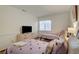 Bright bedroom featuring two twin beds, a modern dresser with television, and natural light from a window at 1721 Sweet Pea Ave, Las Vegas, NV 89183