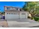 A two-story home with a three car garage, tile roof, and mature shade tree in front yard at 1721 Sweet Pea Ave, Las Vegas, NV 89183