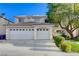 A two-story home with a three car garage, tile roof, and mature shade tree in front yard at 1721 Sweet Pea Ave, Las Vegas, NV 89183