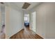 Bright hallway with wood-look flooring leads to a bedroom with a ceiling fan and natural light at 1721 Sweet Pea Ave, Las Vegas, NV 89183