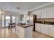 Bright kitchen features stainless appliances, island with counter seating, and door to outdoor pool area at 1721 Sweet Pea Ave, Las Vegas, NV 89183