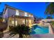 A backyard paradise featuring a pool with a spa, patio cover, and lush tropical landscaping at 1721 Sweet Pea Ave, Las Vegas, NV 89183