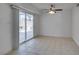 Finished basement area featuring neutral tile flooring, ceiling fan, and sliding door to backyard at 1806 Renada Cir, North Las Vegas, NV 89030