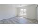 Bright bedroom with neutral walls, window, and light wood-look flooring at 1904 Imola Ct, Las Vegas, NV 89123