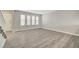 Bright living room featuring three large windows and modern gray wood-look flooring at 2080 Karen Ave # 12, Las Vegas, NV 89169