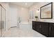 Bathroom showcasing a soaking tub, frameless shower, dual sinks, and stylish dark cabinetry and bright countertops at 2450 Amatrice St, Henderson, NV 89044