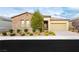 Charming single-story home with stone accents, a two-car garage, and a well-manicured front yard at 2450 Amatrice St, Henderson, NV 89044