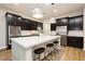 Sleek kitchen featuring dark wood cabinets, stainless steel appliances, and a center island with bar stools at 2450 Amatrice St, Henderson, NV 89044
