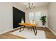 Bright home office featuring wood desk, modern lighting, and black accent wall at 2450 Amatrice St, Henderson, NV 89044