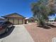 Exterior of the home featuring a spacious driveway, attached garage, and desert landscaping at 2921 Mitzi Ave, Las Vegas, NV 89101