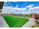 Beautifully landscaped backyard with artificial grass, flowers, and trees at 350 Gandara St, Las Vegas, NV 89138