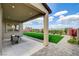 Covered patio with seating overlooks a lush backyard with vibrant landscaping and privacy fencing at 350 Gandara St, Las Vegas, NV 89138