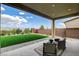 A covered patio overlooks a well-manicured artificial grass backyard at 350 Gandara St, Las Vegas, NV 89138