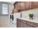 This is a laundry room with white washer and dryer and brown cabinets at 350 Gandara St, Las Vegas, NV 89138