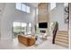 Light-filled living room featuring a stone fireplace, a staircase, and sliding glass doors to the backyard at 350 Gandara St, Las Vegas, NV 89138