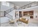 Open-concept living area with marble floors, a cozy sofa, a staircase with iron railings, and an adjacent kitchen at 350 Gandara St, Las Vegas, NV 89138