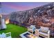Modern backyard features outdoor seating and a small grass area with perimeter fencing at 358 Solitude Peak Ln, Henderson, NV 89012
