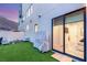 Modern home backyard with artificial turf, fire pit, and sliding glass doors at 358 Solitude Peak Ln, Henderson, NV 89012