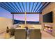 Outdoor seating area with fire place under a pergola, and TV at 358 Solitude Peak Ln, Henderson, NV 89012