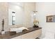 Modern powder room with vessel sink, designer mirror, and unique stone wall detail at 358 Solitude Peak Ln, Henderson, NV 89012