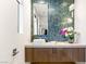 Chic powder room with blue tiled wall, floating vanity, and vessel sink at 358 Solitude Peak Ln, Henderson, NV 89012