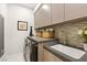 Functional laundry room with a sink, modern washer/dryer, and ample storage at 358 Solitude Peak Ln, Henderson, NV 89012