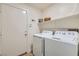 Functional laundry room with washer, dryer, and storage shelves at 3629 Ferrell St, North Las Vegas, NV 89032