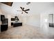 Open-concept living room showcasing the kitchen, tile flooring, and modern ceiling fan at 37 Late Harvest Ave, Pahrump, NV 89060