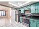 Well-lit kitchen features stainless steel appliances and bright turquoise cabinets at 4036 E Ogden Ave, Las Vegas, NV 89110