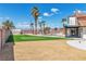 Expansive backyard featuring a sparkling pool, lush green turf, and swaying palm trees at 4061 W Eldorado Ln, Las Vegas, NV 89139