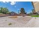 Expansive backyard featuring a paved patio, desert landscaping, and vibrant green synthetic turf at 4061 W Eldorado Ln, Las Vegas, NV 89139