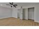 A bright bedroom with a ceiling fan, hardwood floors, closet and door to another room at 4061 W Eldorado Ln, Las Vegas, NV 89139
