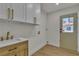 Laundry room featuring built in cabinets, sink, modern fixtures and natural light at 4061 W Eldorado Ln, Las Vegas, NV 89139