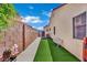 Side yard with artificial turf, a bench, a block wall, and a cacti at 4617 Mancilla St, Las Vegas, NV 89130