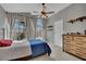 Cozy bedroom features a ceiling fan, dresser, and ample natural light from the large windows at 4617 Mancilla St, Las Vegas, NV 89130