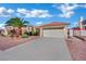 Wide driveway leading to a two-car garage, complemented by desert landscaping and a palm tree at 4617 Mancilla St, Las Vegas, NV 89130