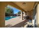 Covered patio with seating area overlooking a private backyard with a sparkling pool at 4937 Semifonte Dr, Pahrump, NV 89061