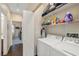 Convenient laundry room with washer, dryer, and shelving for organized storage at 4937 Semifonte Dr, Pahrump, NV 89061