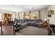 Open concept living area with plush sectional sofa, dark wood floors, and large windows offering natural light at 4937 Semifonte Dr, Pahrump, NV 89061