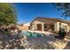Backyard pool with rock waterfall feature, surrounded by a concrete patio and mature landscaping, offering a private retreat at 4937 Semifonte Dr, Pahrump, NV 89061