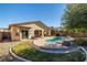 Inviting backyard pool with landscaped rock feature and covered patio, perfect for outdoor relaxation and entertaining at 4937 Semifonte Dr, Pahrump, NV 89061
