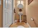 Modern half-bath featuring a pedestal sink, decorative mirror, and tile flooring at 5080 Plymouth Bay Ct, Las Vegas, NV 89141