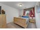 Cozy bedroom with wooden furniture, soft carpet, and a bright window at 5080 Plymouth Bay Ct, Las Vegas, NV 89141