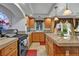 Well-lit kitchen with wood cabinets, granite counters, an island with seating and neutral paint at 5080 Plymouth Bay Ct, Las Vegas, NV 89141
