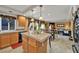 Open kitchen with wood cabinets, island, and eat-in kitchen table with neutral paint at 5080 Plymouth Bay Ct, Las Vegas, NV 89141