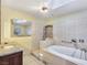 Bright bathroom featuring a soaking tub, tiled walls, and granite countertop sink at 5159 N Monte Cristo Way, Las Vegas, NV 89149