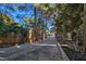 Long driveway with unique decorative elements and mature landscaping on either side at 5159 N Monte Cristo Way, Las Vegas, NV 89149