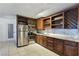 Modern kitchen with stainless steel appliances, dark wood cabinets, granite countertops, and tile flooring at 5159 N Monte Cristo Way, Las Vegas, NV 89149