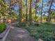 Beautiful landscaping with gravel walkways and mature trees that cover a large portion of the yard and a concrete retaining wall at 5159 N Monte Cristo Way, Las Vegas, NV 89149